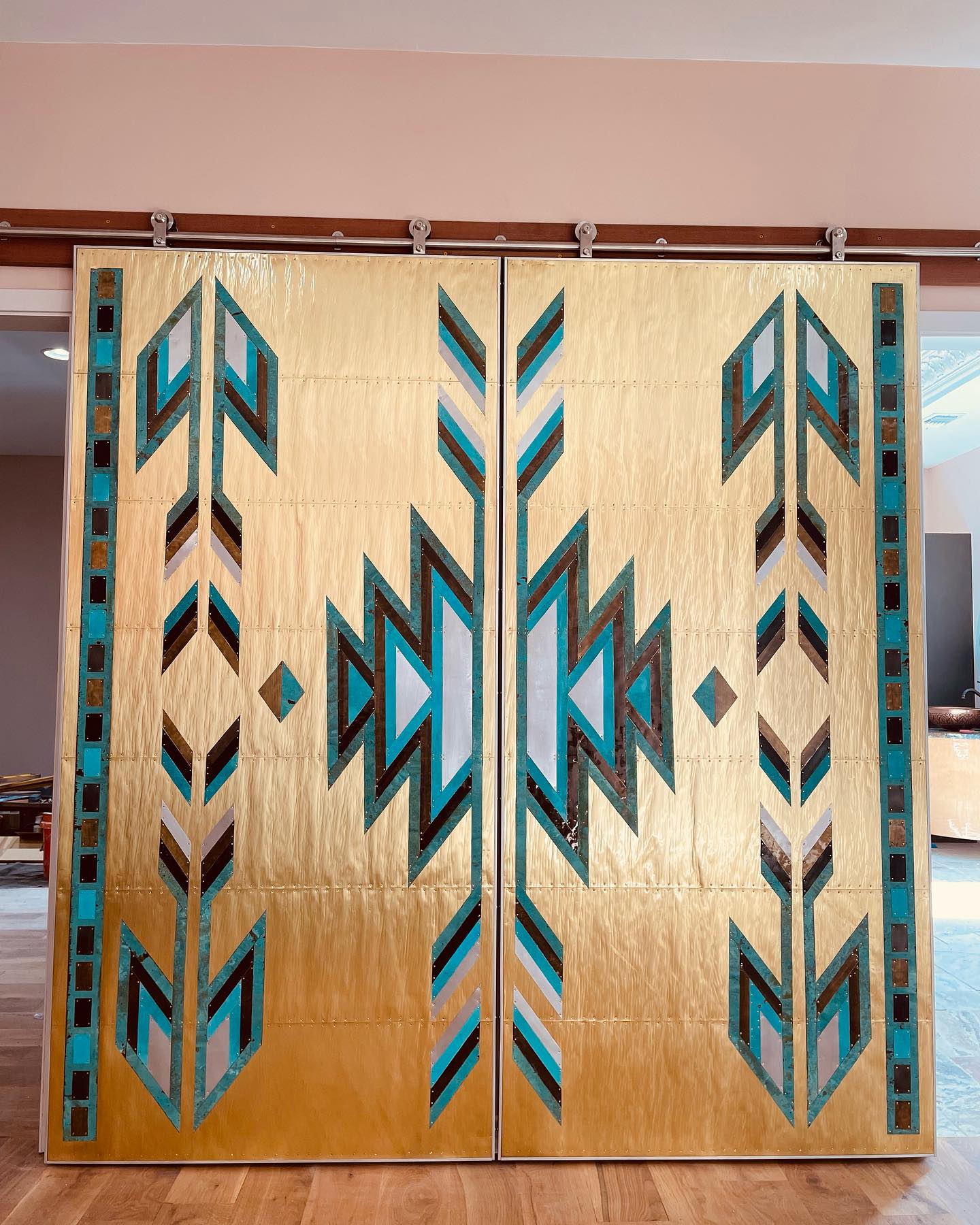 Gold and turquoise geometric barn door installation by Zeke Trainum