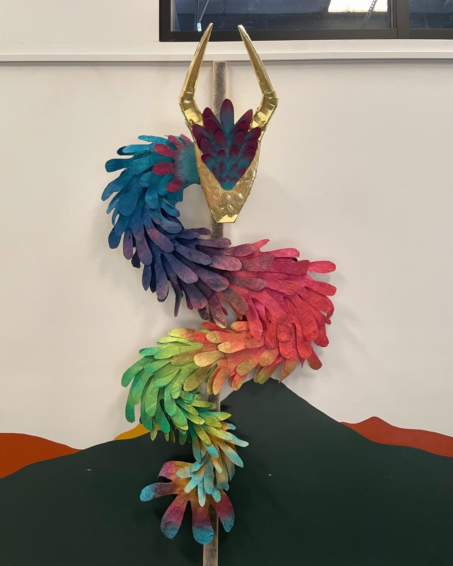 Rainbow dragon sculpture with metal horns by Zeke Trainum