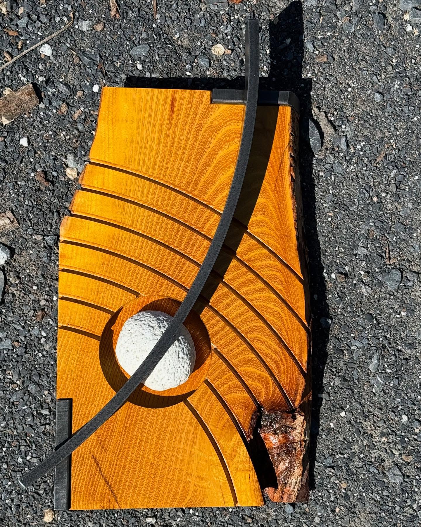 Wood, steel, and stone sculpture by Zeke Trainum